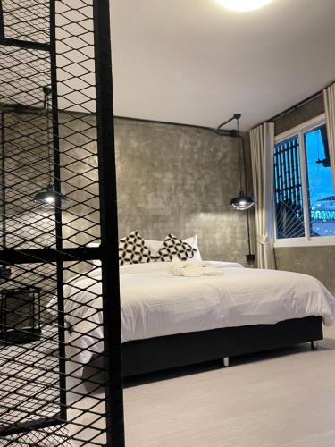 a bedroom with a white bed and a window at Dvilla in Ban Bang Saen (1)