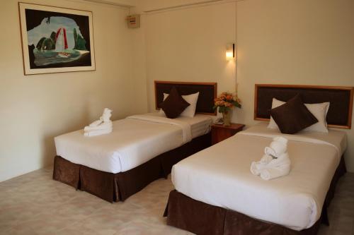 zwei Betten in einem Hotelzimmer mit Handtüchern darauf in der Unterkunft Hotel De Ratt in Phuket