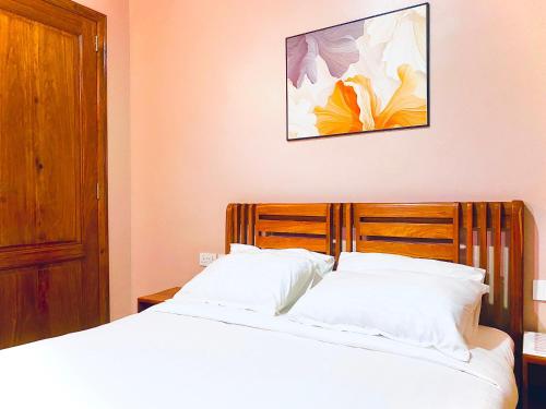 a bedroom with two beds and a picture on the wall at Clisa Rest House in Karatu