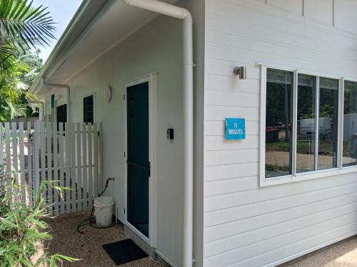 a white house with a door and a window at Rosalita, Picnic Bay in Picnic Bay