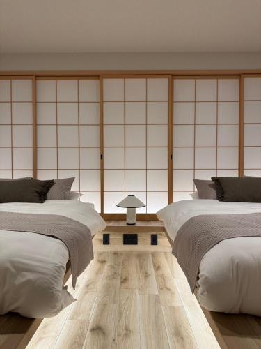 a room with two beds and a table between them at New open 都心の一軒家貸切 232平米 新宿駅4分 渋谷10分 無料駐車場3台 最寄駅2分 in Tokyo