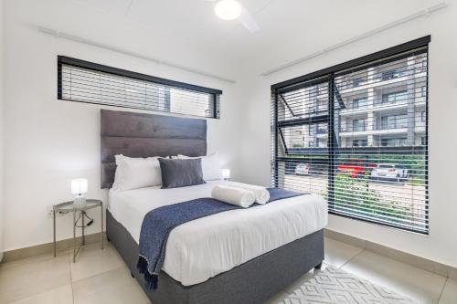a bedroom with a large bed and a window at Ballito Village Luxury Apartments in Ballito