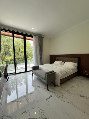 a bedroom with a bed and a large window at Aldeoz Villa Sentul in Babakan Madang