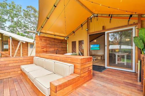 a patio with a couch on a wooden deck at Ingenia Holidays Noosa in Tewantin