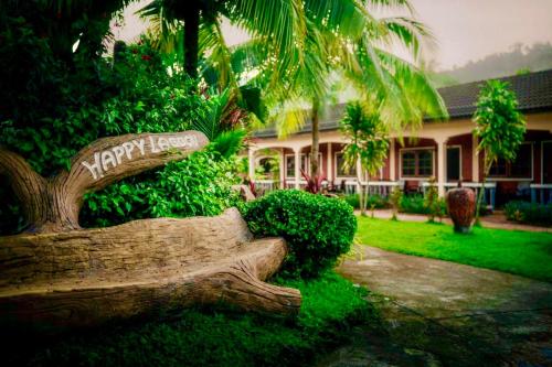 a house with a sign on a tree stump at Happy Lagoon Bungalow in Khao Lak
