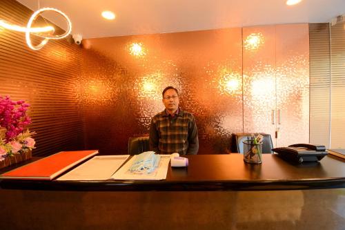 a man sitting at a desk in an office at Hotel O Grand Lotus Inn in Siroli