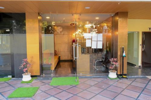 a lobby of a building with potted plants at Hotel O Grand Lotus Inn in Siroli