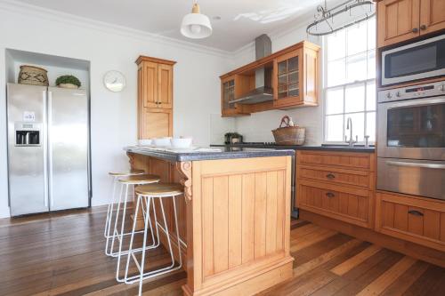 une cuisine avec des armoires en bois et des appareils en acier inoxydable dans l'établissement The Holiday House - Newly listed, à Pottsville