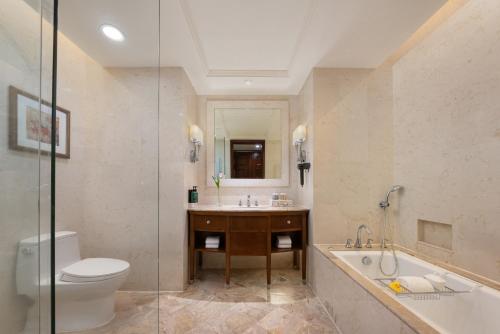 a bathroom with a toilet and a tub and a sink at Shangri-La Wenzhou in Wenzhou