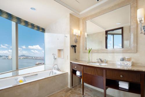 a bathroom with a tub and a sink and a large window at Shangri-La Wenzhou in Wenzhou
