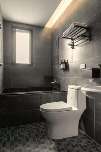 a bathroom with a toilet and a sink and a tub at Yuzhi Wenlv B&B in Hualien City