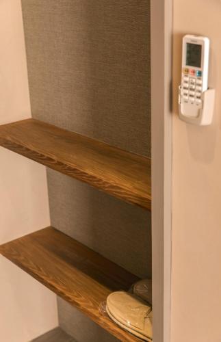 a cell phone hanging on a shelf in a closet at Yuzhi Wenlv B&B in Hualien City