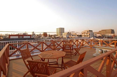 a patio with chairs and a table on a balcony at Hotel Imalle Haneda in Kawasaki