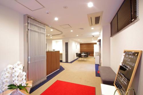 un hall de bureau avec un tapis rouge et une réception dans l'établissement Hotel Imalle Haneda, à Kawasaki