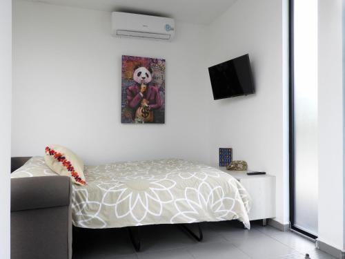 a bedroom with a bed and a tv on a wall at L W H Hotel & Glamping Container Park in Silao