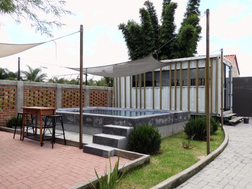 a patio with a table and a swimming pool at L W H Hotel & Glamping Container Park in Silao