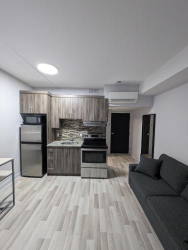 a living room with a couch and a kitchen at CDQI Hotel in Ottawa