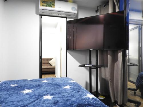a bedroom with a bed and a tv in a room at L W H Hotel & Glamping Container Park in Silao