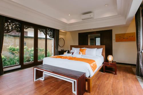 a bedroom with a large bed and a large window at Villa Anggrek Jimbaran in Jimbaran