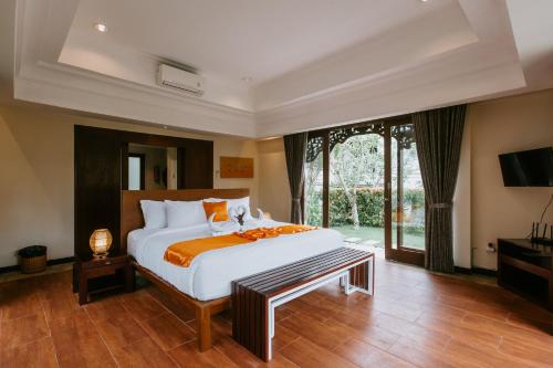 a bedroom with a large bed and a large window at Villa Anggrek Jimbaran in Jimbaran