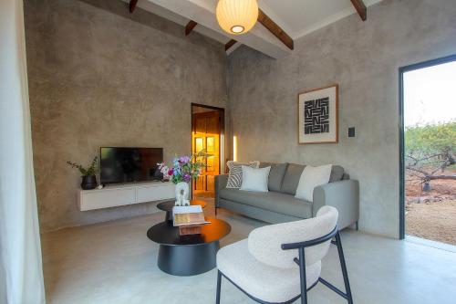 a living room with a couch and a table at Pillows Luxury Safari Villa, Wood-Fired Hottub, Giraffe-Feeding-Tower, Large Private Pool in Marloth Park
