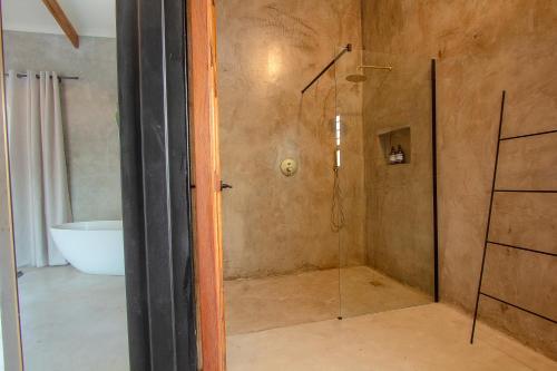a bathroom with a shower and a bath tub at Pillows Luxury Safari Villa, Wood-Fired Hottub, Giraffe-Feeding-Tower, Large Private Pool in Marloth Park