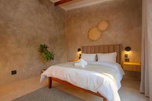 a bedroom with a large bed with a stuffed animal on it at Pillows Luxury Safari Villa, Wood-Fired Hottub, Giraffe-Feeding-Tower, Large Private Pool in Marloth Park