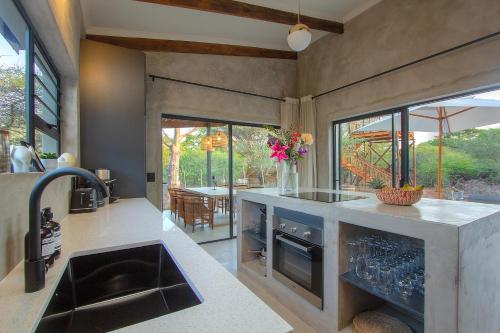 a kitchen with a sink and a counter at Pillows Luxury Safari Villa, Wood-Fired Hottub, Giraffe-Feeding-Tower, Large Private Pool in Marloth Park