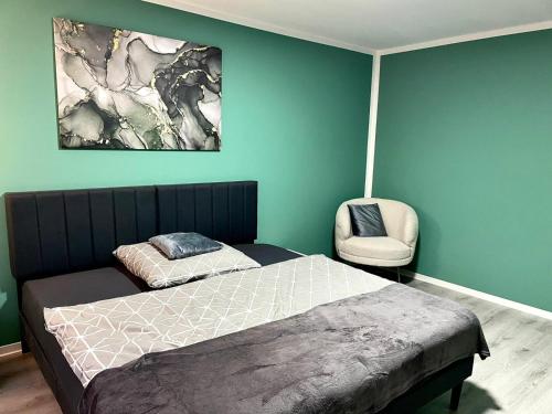 a bedroom with a bed and a chair at Appartement 3 - geräumige Wohnung mit eigener Küche, Bad und Gartenblick in Salzgitter