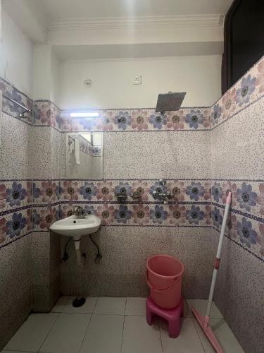 a bathroom with a sink and a toilet and a mirror at Prakruti Homestay in Rishīkesh