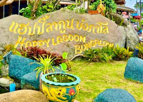 a sign for the newnatural india happy lagoon in a garden at Happy Lagoon Bungalow in Khao Lak