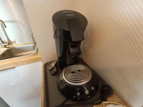 une cafetière noire assise sur une étagère à côté d'un évier dans l'établissement La bulle de Luchon, proche télécabine, 4 pers, à Luchon