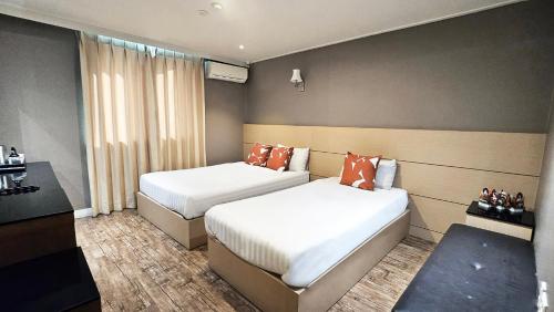 a hotel room with two beds and a window at Jeonju Pungnam Family Hotel in Jeonju