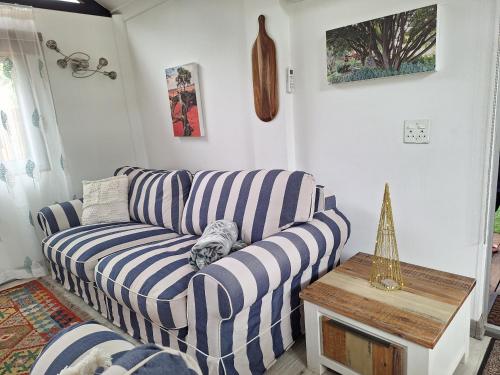 a living room with a blue and white striped couch at Tree Living in Krugersdorp