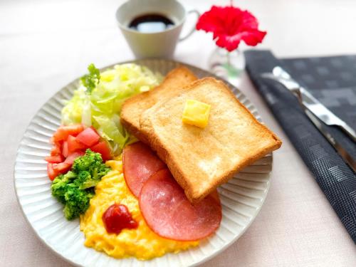 a plate of breakfast food with eggs ham and vegetables at Seaside Village 13(シーサイドヴィレッジ・サーティーン) in Ishigaki Island