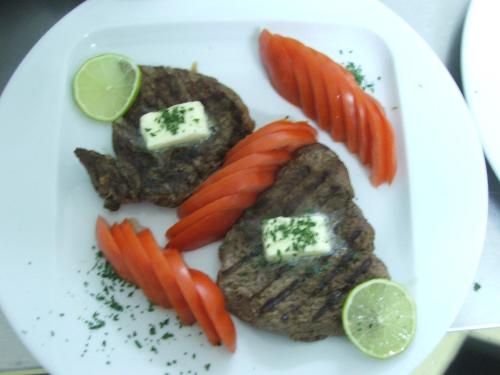 a plate of food with meat and vegetables on it at Anthimos in Baile Felix