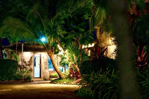 a building with palm trees in front of a doorway at Happy Lagoon Bungalow in Khao Lak