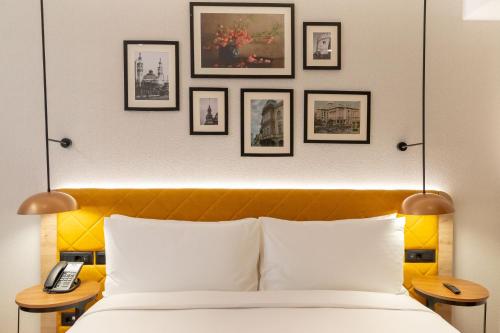 a bedroom with a bed and framed pictures on the wall at Hilton Garden Inn Baku in Baku