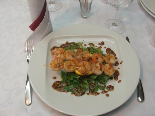 a plate of food with shrimp and greens on a table at Anthimos in Baile Felix