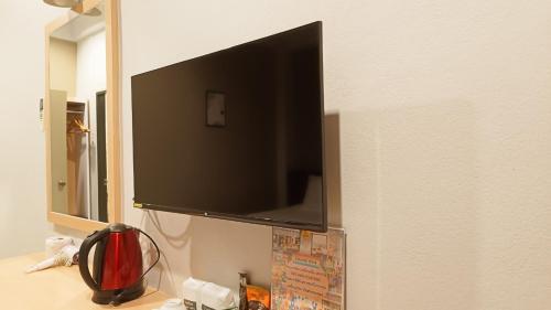 a flat screen tv hanging on a wall at The Beginning Hotel in Betong