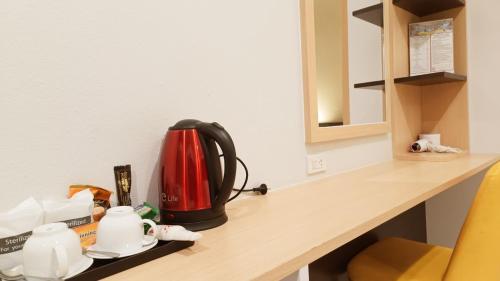 a red and black kettle sitting on a counter at The Beginning Hotel in Betong