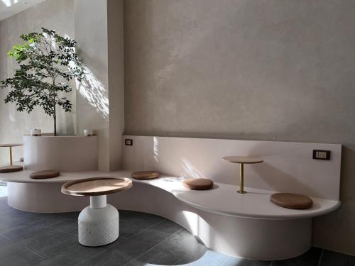 a bathroom with a tub with two stools and a plant at Yuzhi Wenlv B&B in Hualien City