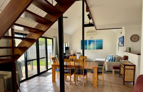 a dining room and living room with a table and chairs at Margaret River Beach Houses in Gnarabup