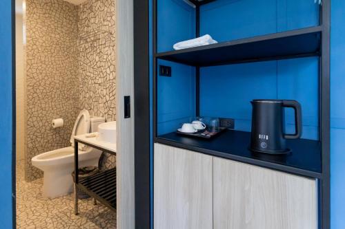 a blue bathroom with a toilet and a sink at Penpark Place in Bangkok