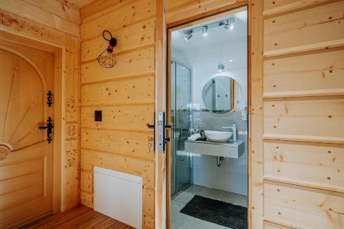 een badkamer met een glazen douche en een wastafel bij Topory Prestige House sauna & jacuzzi in Zakopane