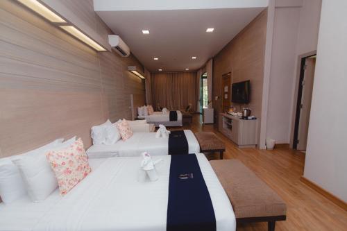 a hotel room with two beds and a living room at Treescape Resort Chiangmai in Chiang Mai