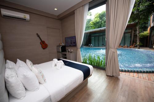 a bedroom with a bed and a swimming pool at Treescape Resort Chiangmai in Chiang Mai