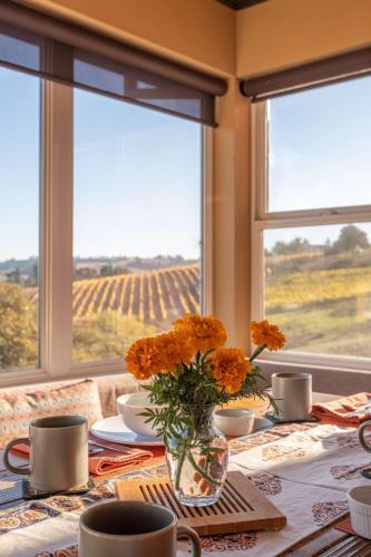 a table with orange flowers in a vase on it at 5 Acre Villa Retreat with Vineyard Pool Spa & Amazing Views of Sonoma County in Sebastopol