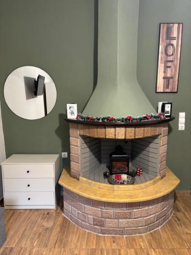 a brick fireplace with a christmasreath on top of it at Paradise of Meteora A in Kastrákion