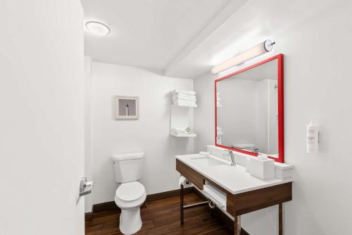 a bathroom with a toilet and a sink and a mirror at Hampton Inn Pennsville in Pennsville